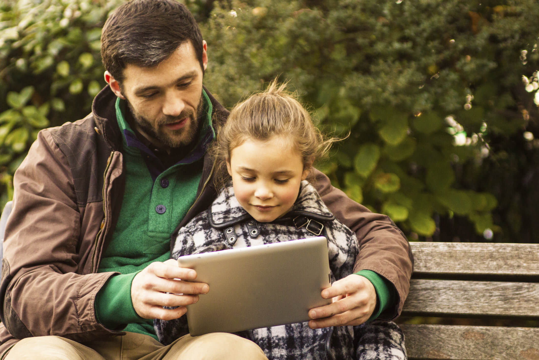 Man and girl reading on a bench