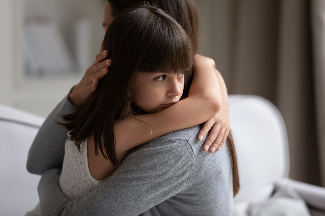 Young child hugging adult