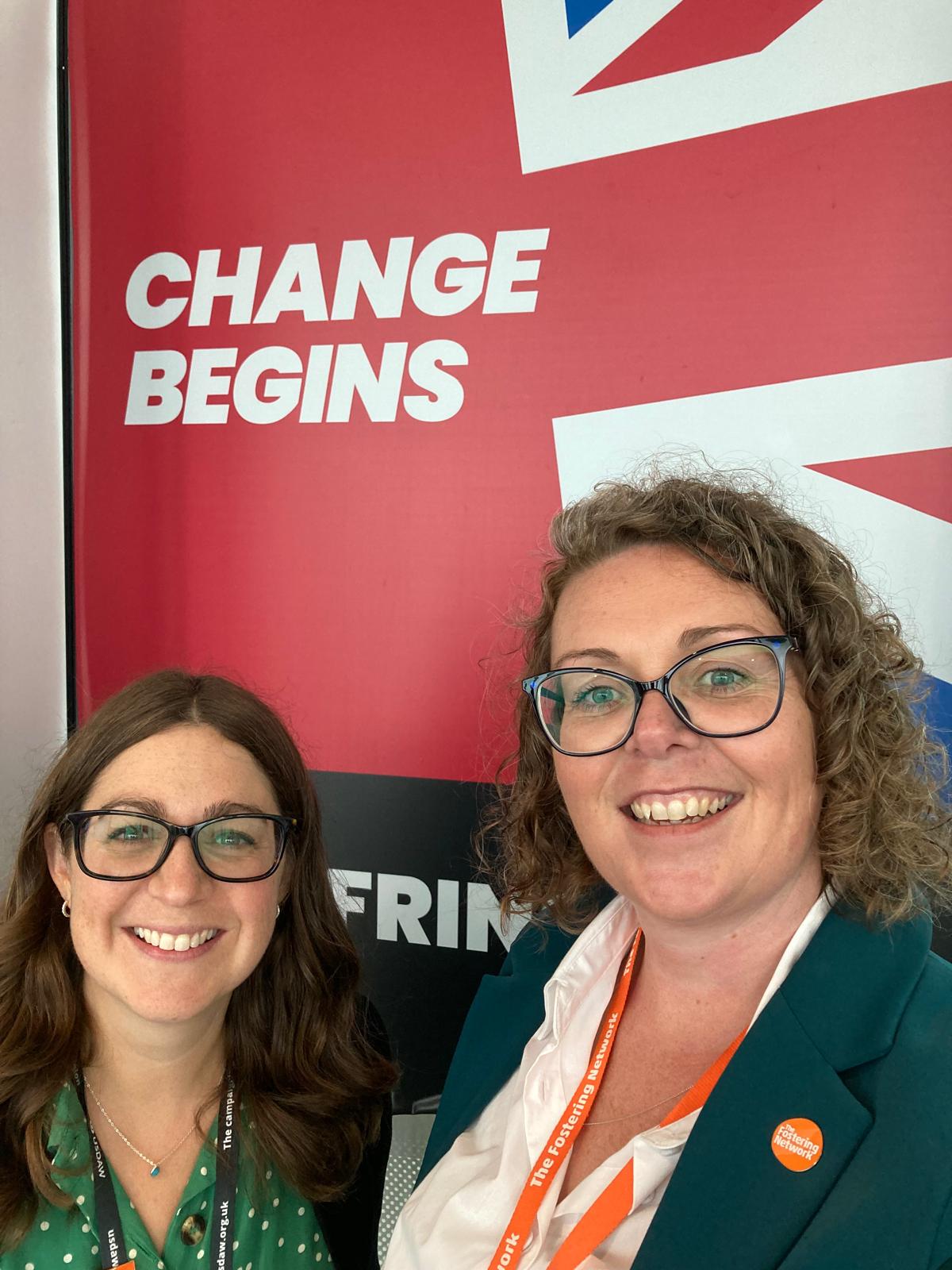 A selfie of chief executive at The Fostering Network Sarah Thomas and Head of Policy Natalie Williams at The Labour Party conference. They are stood in front of a banner which says 'Change Begins'.